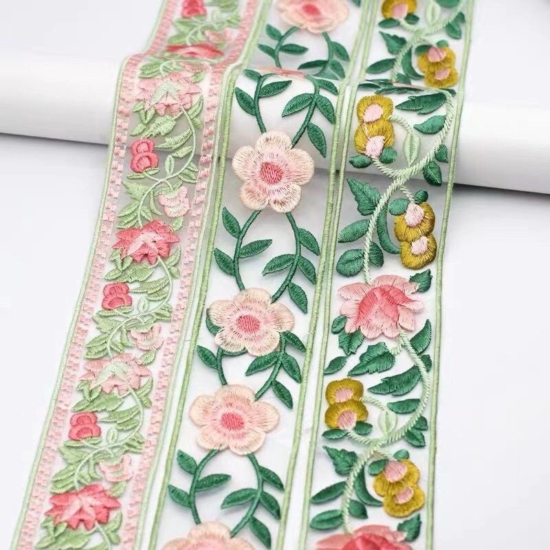Applique, stone work and finishing on embroidered fabric
